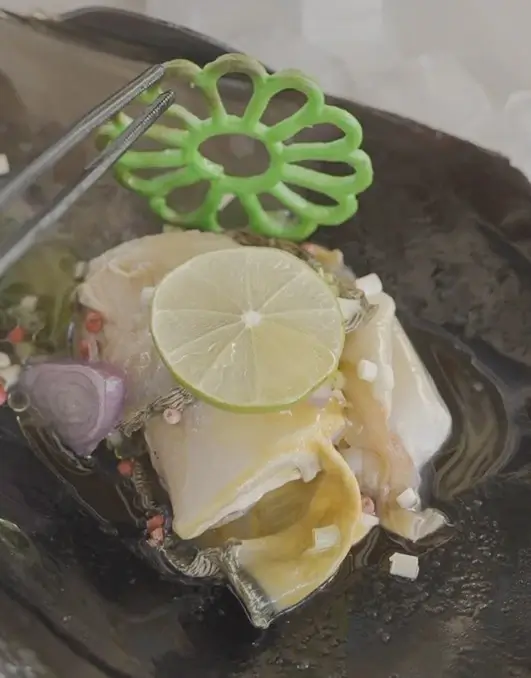 A piece of fish garnished with fresh lime slices