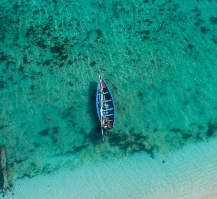 Aerial view of a small boat floating on the blue ocean