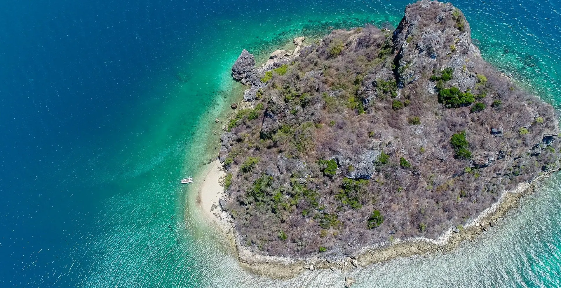 Aerial view of a small, rocky island with a sandy beach