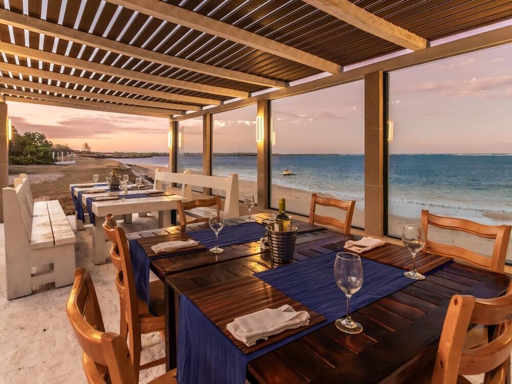 Beachfront dining with wooden tables and blue tablecloths