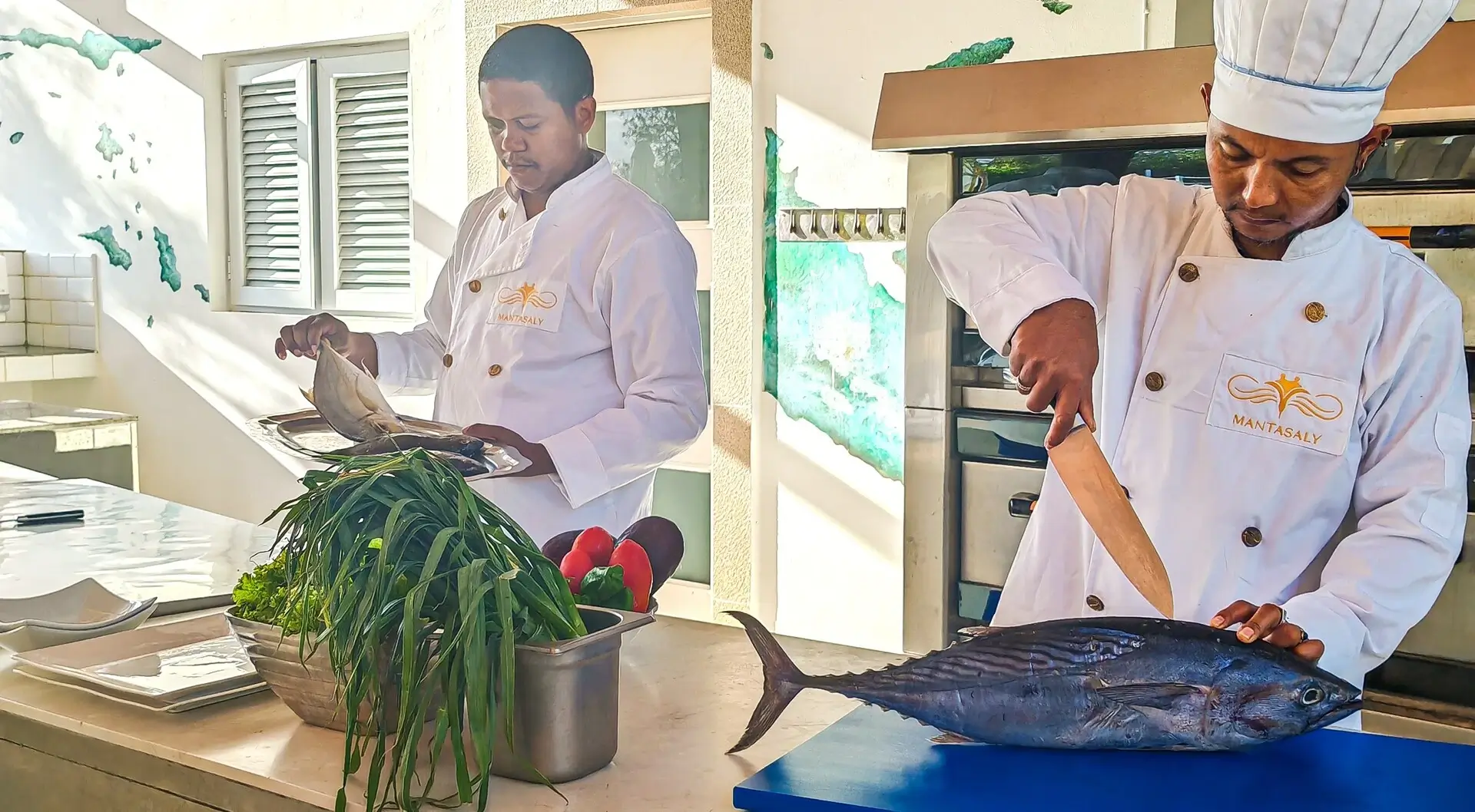 Chefs preparing fresh fish in kitchen