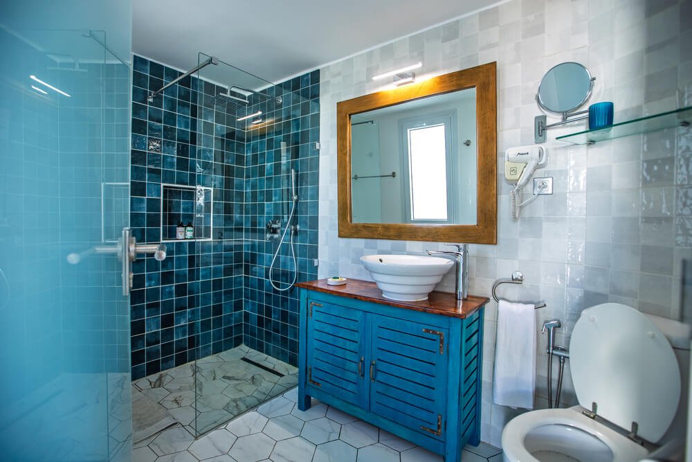 Modern bathroom featuring blue tiled walls