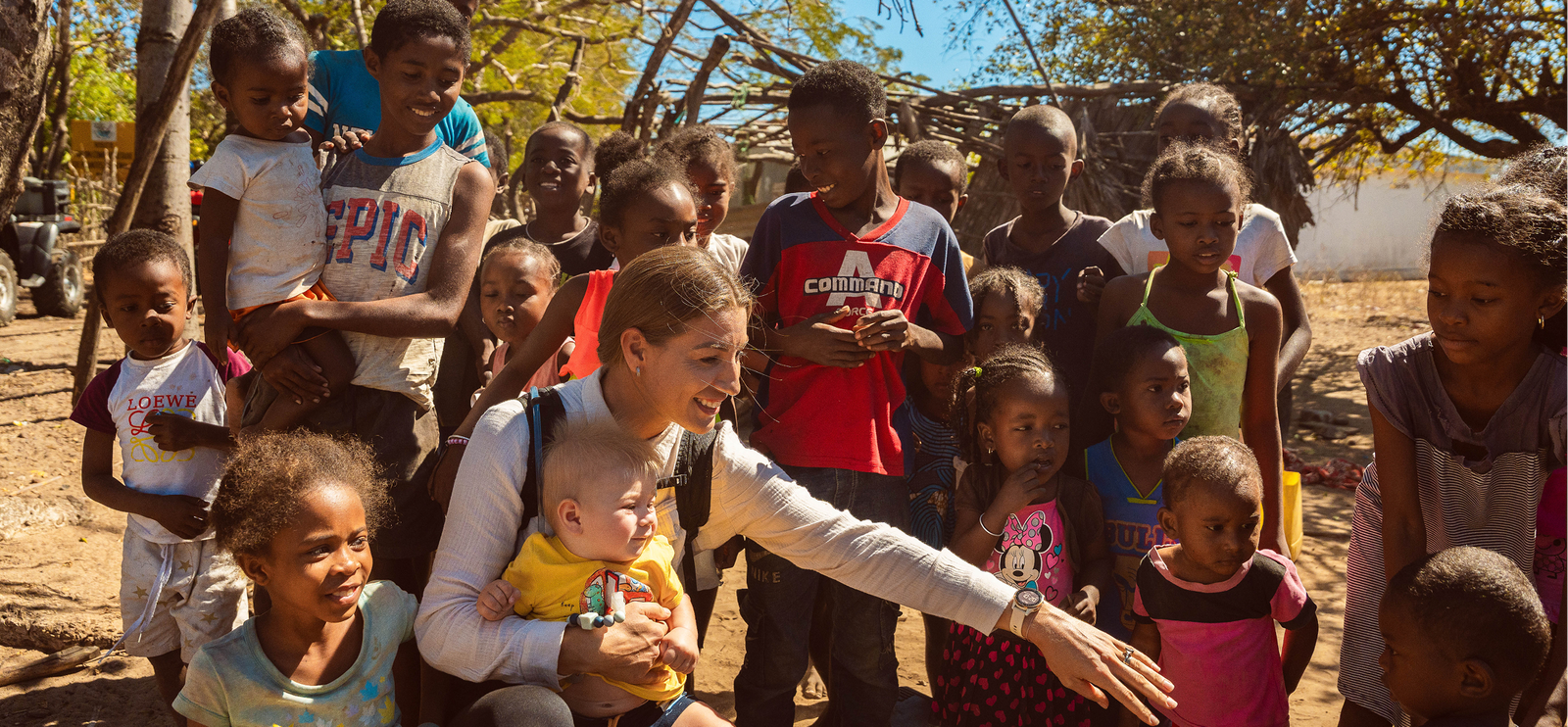 Woman surrounded by joyful children outdoors