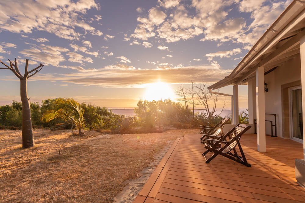 Sunset view from a wooden deck with two chairs