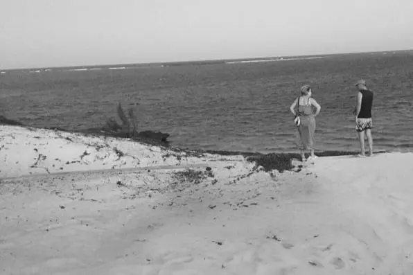 Two people standing on the beach